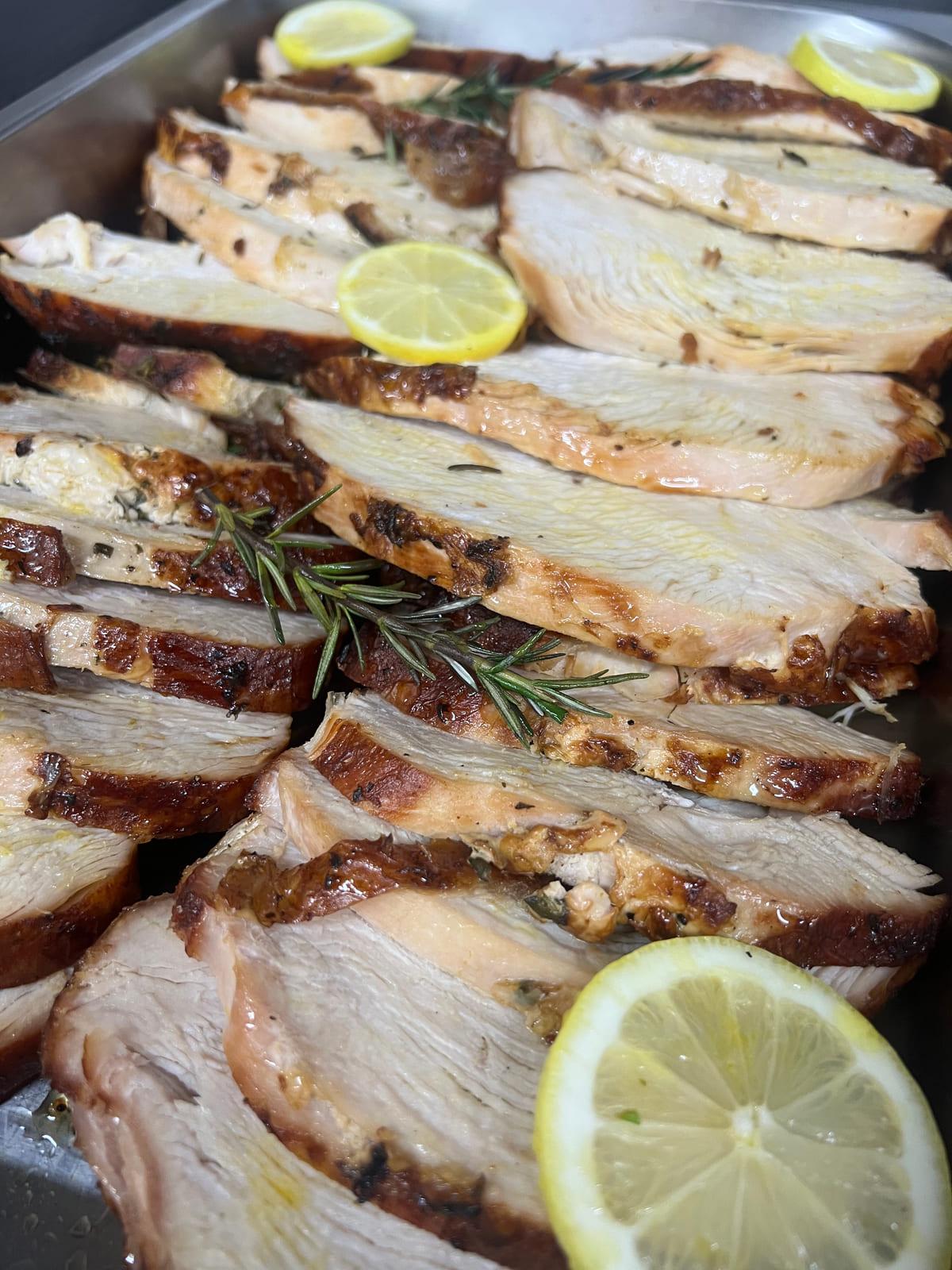 Sliced roast meat finished with lemon and fresh rosemary, prepared for a function carvery